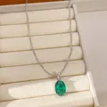 Detailed view of an elegant oval green gemstone necklace pendant on a silver chain - Necklace / Silver-Green
