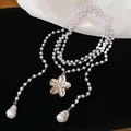 Détail d'un collier multicouche de style français avec un élégant pendentif fleur dorée - Collier-Argent-Blanc
