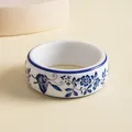 Detail view of a resin bangle featuring blue and white porcelain floral and butterfly patterns - Butterfly Print / Blue & White