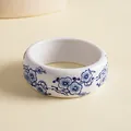 Detailed close-up of a wide resin bangle with blue and white floral porcelain style print - Peach Blossom Print / Blue & White