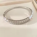 Detailansicht eines silberfarbenen Zirkonia-Armreifs mit Durchbruchmuster in Box - Silber