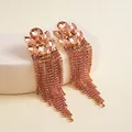 Detailansicht von roségoldenen Quastenohrringen mit Pfirsichkristallen und Strass - Silberner Ohrstecker - Champagner