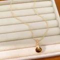 Detail van 18k vergulde kalebas hanger ketting met tijgeroog steen en zirkonia's. - Goudbruin