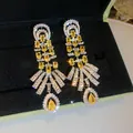 Detailed view of luxury palace style earrings featuring sparkling yellow water drop zircons - Silver