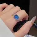 Détail macro d'une bague de luxe avec pierre bleue taille coussin et anneau pavé - Bague / Bleu