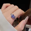 Gros plan d'une bague en argent avec une pierre de zircone cubique violette éclatante. - Bague / Violet
