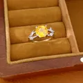 Gedetailleerd aanzicht van een zilveren ring met gele zirkoon in een fluwelen doos - Ring / Zilver-Geel