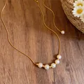 Close-up detail of an elegant 14k gold plated chain necklace featuring five white pearls - Elegant Artificial Pearl Strand Style / Gold