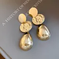 Eleganti orecchini a goccia color oro con dischi martellati e grandi pendenti a goccia. - Oro