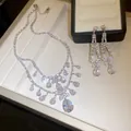 Nahaufnahme des funkelnden Zirkonia-Blumen- und Tropfen-Halsketten- und Ohrringsets - Silber-Weiß