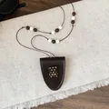 Macro-opname van retro bruin leren beren hanger met een mooie kralen ketting - Ketting-Bruin-Beer