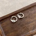 Close-up of French style silver hoop earrings with a large round cubic zirconia stone. - Single Zircon Round Hoop / Silver