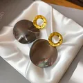 Detailed shot of vintage geometric acetate earrings with gold textured rings. - Gold-Grey