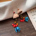 Macro detail of vintage ethnic style tassel earrings crafted from wood and plant seeds - S / Coffee-Red-Blue