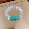 Close-up of a resin beaded bracelet with turquoise accents and sparkling CZ spacers - Green & Transparent