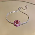 Close-up detail of an adjustable zircon bracelet with a red oval gemstone halo - Magenta Pendant Style / Silver Rose Red