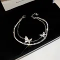 Detailansicht eines zweilagigen Armbands mit funkelnden Zirkonen und Schmetterlingen - Silber