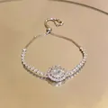 Close-up of sparkling oval zircon pendant with double halo on silver-tone bracelet - Transparent White Pendant Style / Silver White