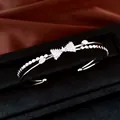 Detailansicht eines silberfarbenen zweilagigen Armreifs mit funkelnder Zirkonia-Schleife - Silber