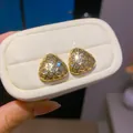 Gedetailleerde weergave van driehoekige 18k vergulde oorknopjes met fonkelende zirkonia. - Geometrische Driehoek (Verguld) / Goud