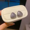 Detailopname van driehoekige oorknopjes met zirkonia en een 18 karaats witgouden plating - Geometrische Driehoek (Verguld) / Zilver