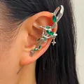 Gothic dark style silver snake ear cuff featuring emerald green crystals on a human ear - Snake Green Rhinestone Ear Cuff (DZ-374) / White K and Green