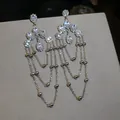 Macro view of luxurious silver tassel earrings with sparkling oval zircon stones - Long Tassel Silver Post Style / 1 Pair Pack / Silver