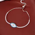 Macro view of silver adjustable tennis bracelet featuring a zircon shell evil eye pendant - Blue