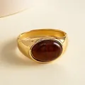 Detailed macro view of a vintage gold metal bangle with marbled oval resin stone - Gold Brown