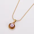Macro view of an elegant gold shell pendant with a vibrant purple pearl centerpiece - Gold Pink