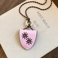 Vue détaillée du collier pince à lunettes en cuir rose avec motifs de soleil brodés. - Rose