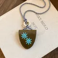 Détail du collier porte-lunettes en cuir rétro avec broderie soleil sur un livre. - Vert Foncé
