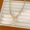 Detailansicht eines Jade-ähnlichen Flaschenkürbis-Anhängers an einer doppelten Goldkette. - Halskette-Grün (Gold Plattiert)