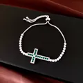 Bracelet croix argenté ajustable avec zircons verts et blancs sur fond noir. - Argent-Vert