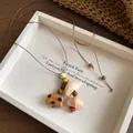 Close-up of vintage handmade wooden necklace with bear pendant and shells in a tray - Necklace-Coffee-White-Dog