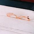 Close-up of rose gold open rings with cubic zirconia inlay in a velvet box. - Two-Piece Set / Rose Gold