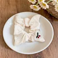 Gros plan d'un chouchou en dentelle blanche avec un joli patch cœur brodé cerise. - Chouchou Cœur Broderie Cerise / Style Dentelle Blanc Cassé