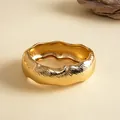 Detail van een grove gouden armband met een unieke golvende rand en geplooide textuur - Basis stijl / Goud