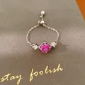 Detailweergave van een verstelbare zilveren kettingring met magenta zirkoon en stenen - Rozerood / Zilver