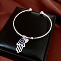 Vue détaillée du jonc argenté avec main de Fatma mauvais œil bleu et breloque cœur - Argent Bleu