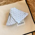 Macrodetail van blauwe haarklem met stippen op een stijlvolle studio-achtergrond - Haarklem / Blauw