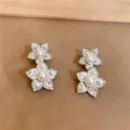 Detailansicht der silberfarbenen Blumenohrringe mit Zirkonia und weißen Perlen. - Doppelschichtige Blume / Silber