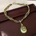 Collier bohème tressé avec grand pendentif goutte vert sur présentoir en velours brun - Pendentif Forme de Poire / Vert