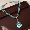 Détail d'un collier bohème en perles avec cordons de soie bleus et pendentif turquoise. - Pendentif Forme de Poire / Bleu