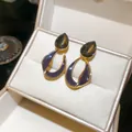Detail of Maillard style earrings with 18k gold plating and dark smoky teardrop stone. - Gray