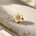 Detailopname van een gardenia-bloembroche met emaille blaadjes en strass-steentjes. - Gardenia Brosche