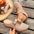 Close-up view of beige floral cutout wedge sandals with adjustable buckle strap detail - Beige