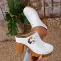 Detail view of white platform clogs featuring gold rivets and thick block heel - 35 / White