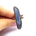 Detailed hand-held view of a vintage raw blue crystal stone ring with antiqued copper. - Style 4
