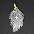 Close-up of a carved translucent crystal leaf pendant with gold-plated zircon inlay - White Crystal